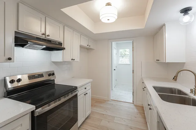 a kitchen with stainless steel appliances granite countertop a sink and a stove
