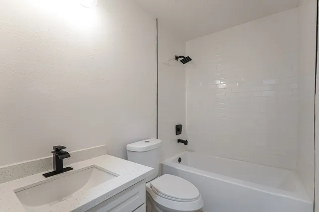 a bathroom with a toilet a sink and bathtub