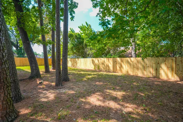a view of a yard with wooden fence