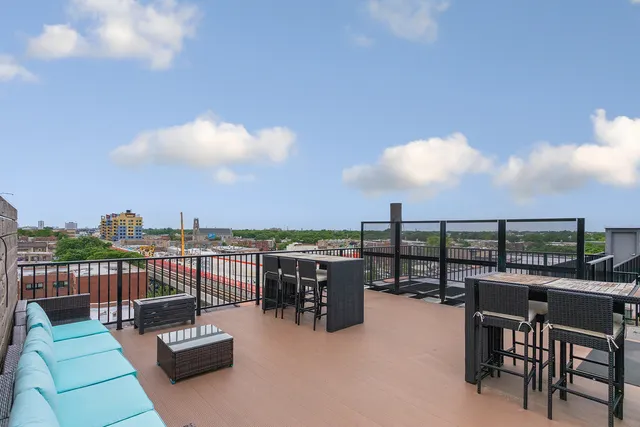 a view of a roof deck with couches and potted plants
