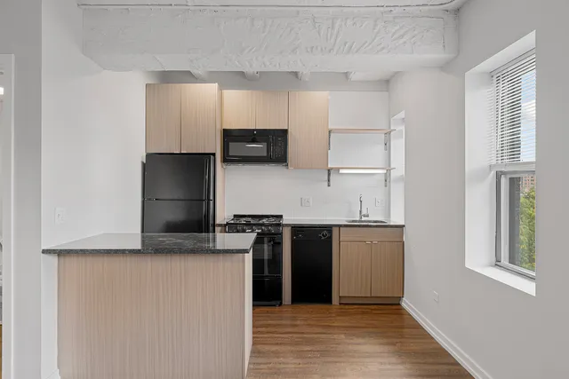 a kitchen with kitchen island granite countertop a stove and a refrigerator