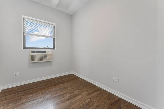 a room with wooden floor and windows