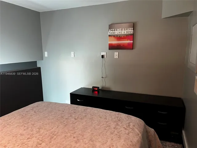 a bedroom with a bed and a black cabinet