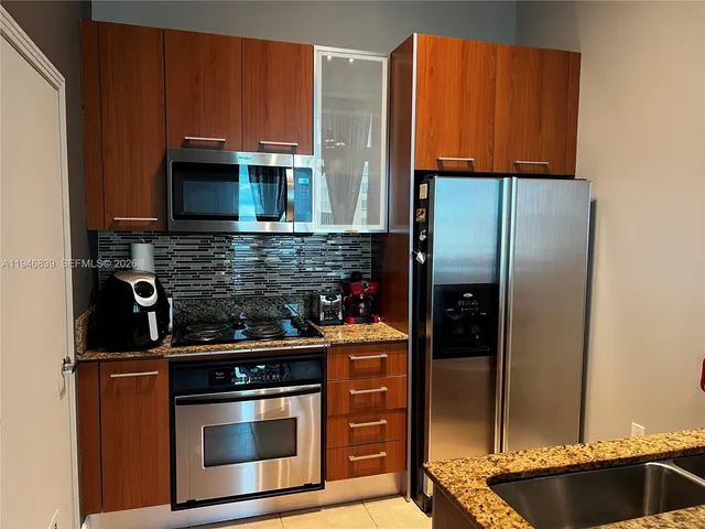 a kitchen with stainless steel appliances wooden cabinets and a stove top oven