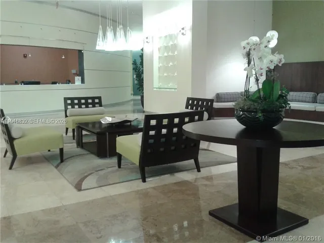 a lobby with furniture and potted plants