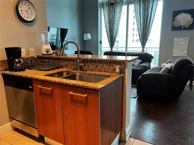 a kitchen with stainless steel appliances granite countertop a sink and a large window
