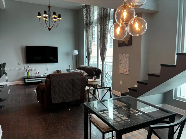 a living room with furniture a flat screen tv and kitchen view