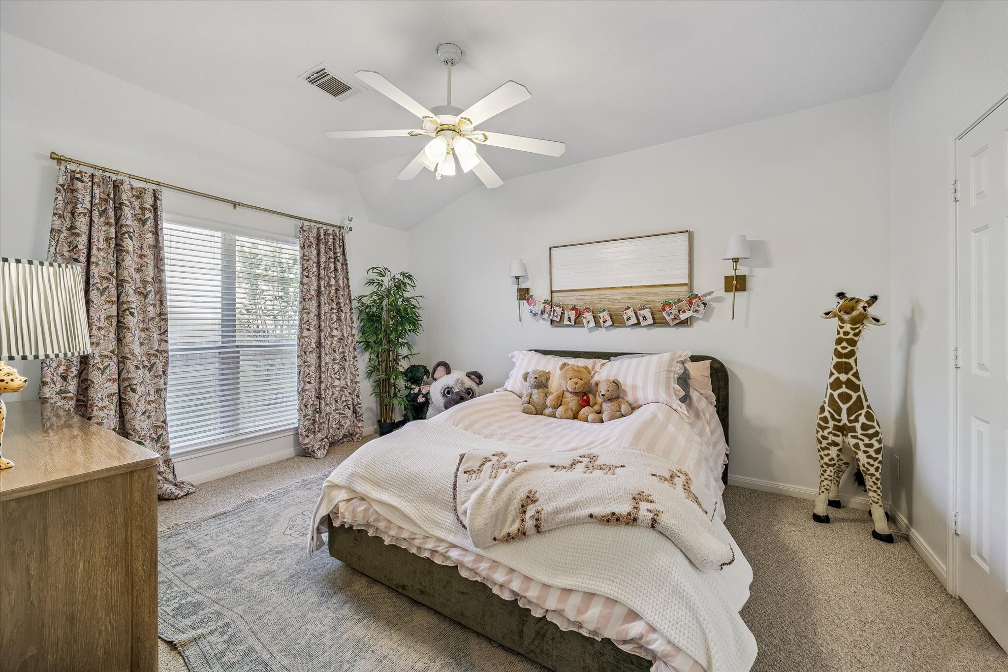 6507 Haughton Court Spring, TX 77389 - Photo 12 of 24 a bedroom with a large bed and a chandelier