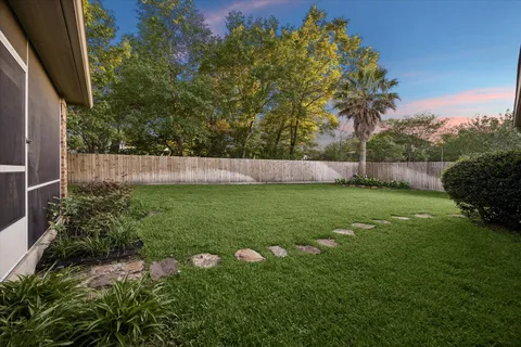 a view of a house with backyard and a tree