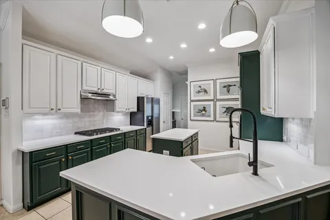 a kitchen with a refrigerator a sink cabinets and wooden floor