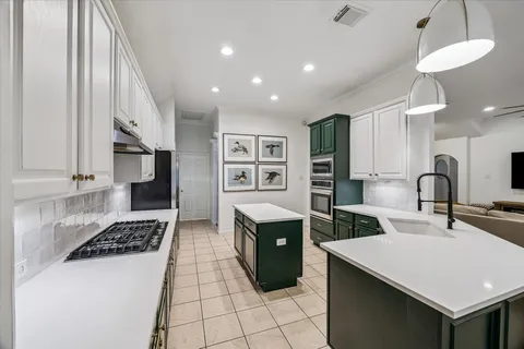 a kitchen with a sink a stove and cabinets