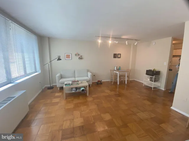 a living room with furniture a dining table and view of kitchen