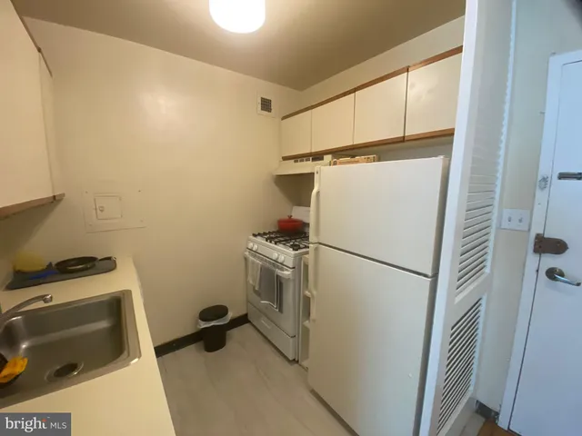 a white refrigerator freezer and a stove sitting inside of a kitchen