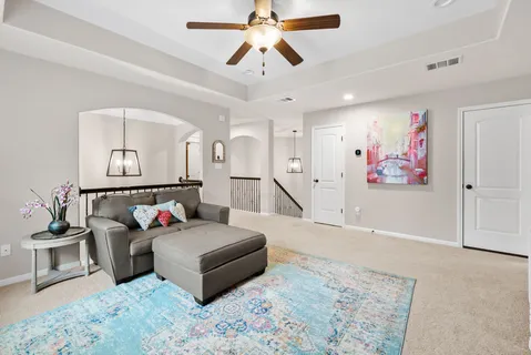 a living room with furniture and a chandelier