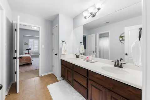 a en suite bathroom with a double vanity sink and a mirror