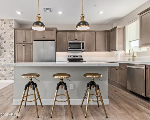 a kitchen with stainless steel appliances a stove a refrigerator and a sink