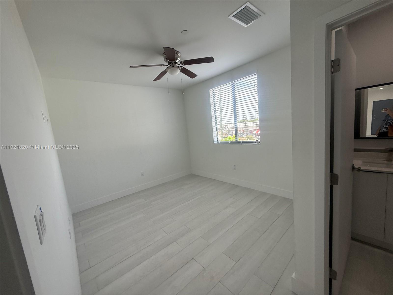 909 East 24th Street, Unit 403 Hialeah, FL 33013 - Photo 11 of 20 a view of a livingroom with a ceiling fan and window