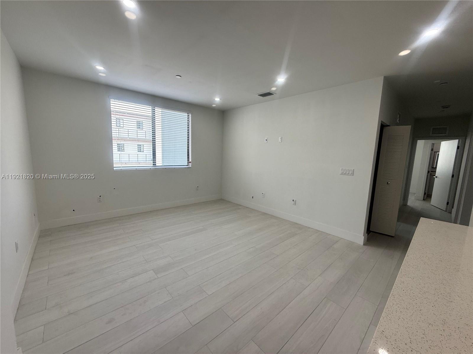 909 East 24th Street, Unit 403 Hialeah, FL 33013 - Photo 17 of 20 an empty room with wooden floor and entrance