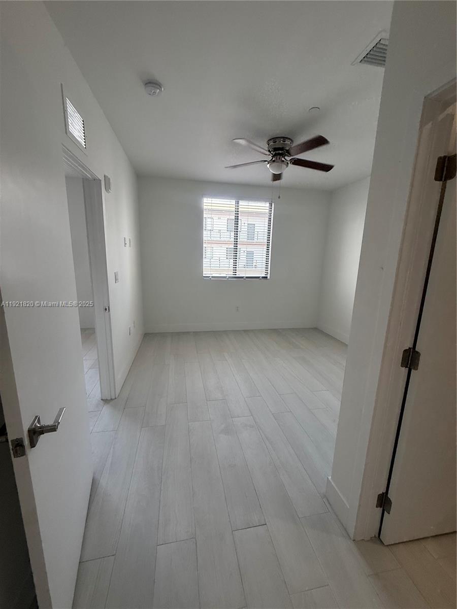 909 East 24th Street, Unit 403 Hialeah, FL 33013 - Photo 3 of 20 wooden floor in an empty room with a window