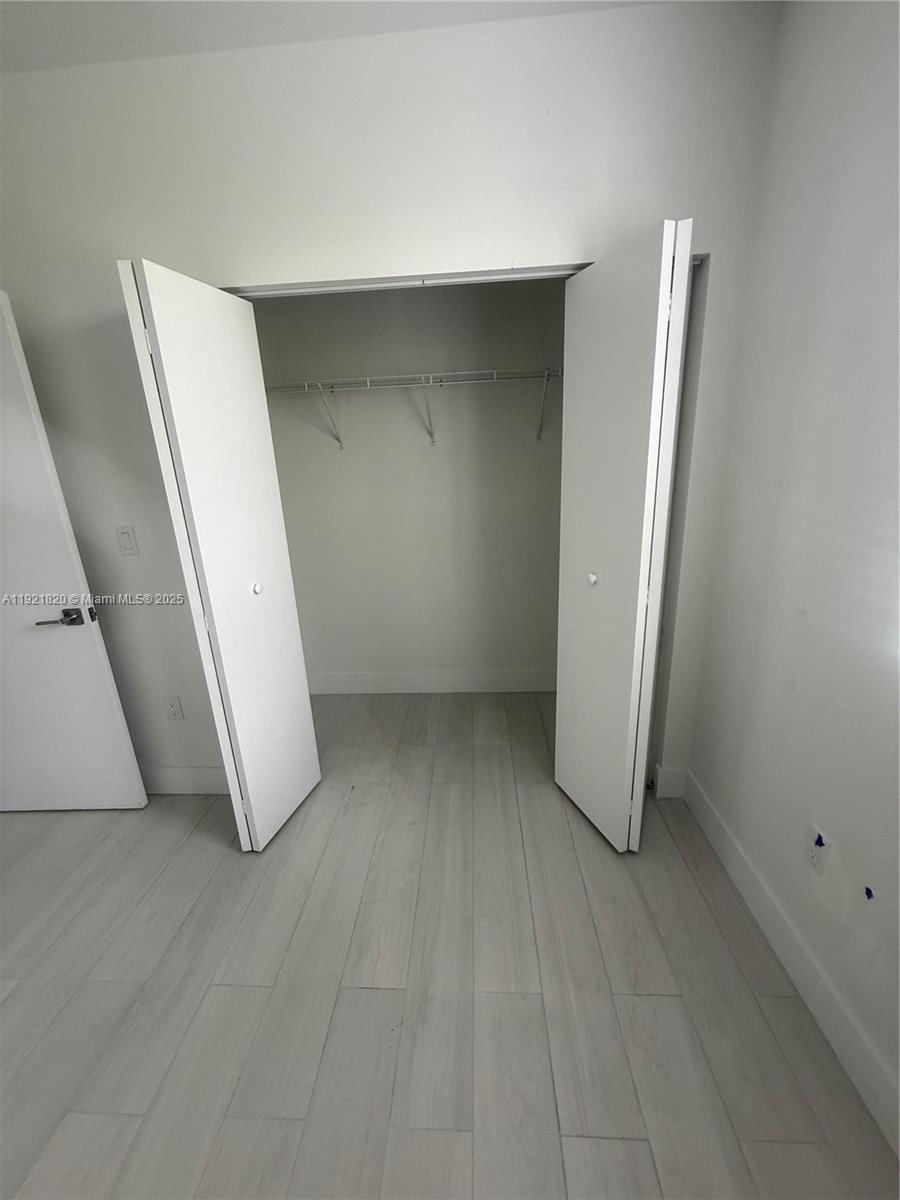 909 East 24th Street, Unit 403 Hialeah, FL 33013 - Photo 6 of 20 an empty room with wooden floor and entrance