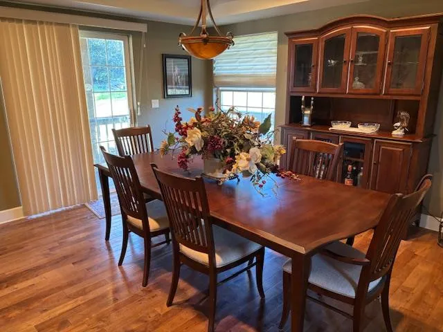 a dining room with furniture window and wooden floor