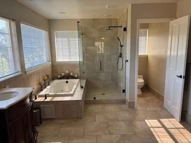 a bathroom with a sink a toilet and shower