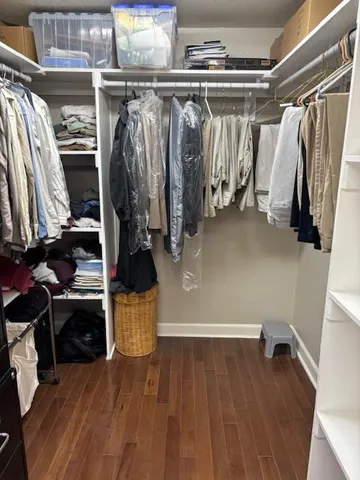a view of walk in closet with clothes and shoes