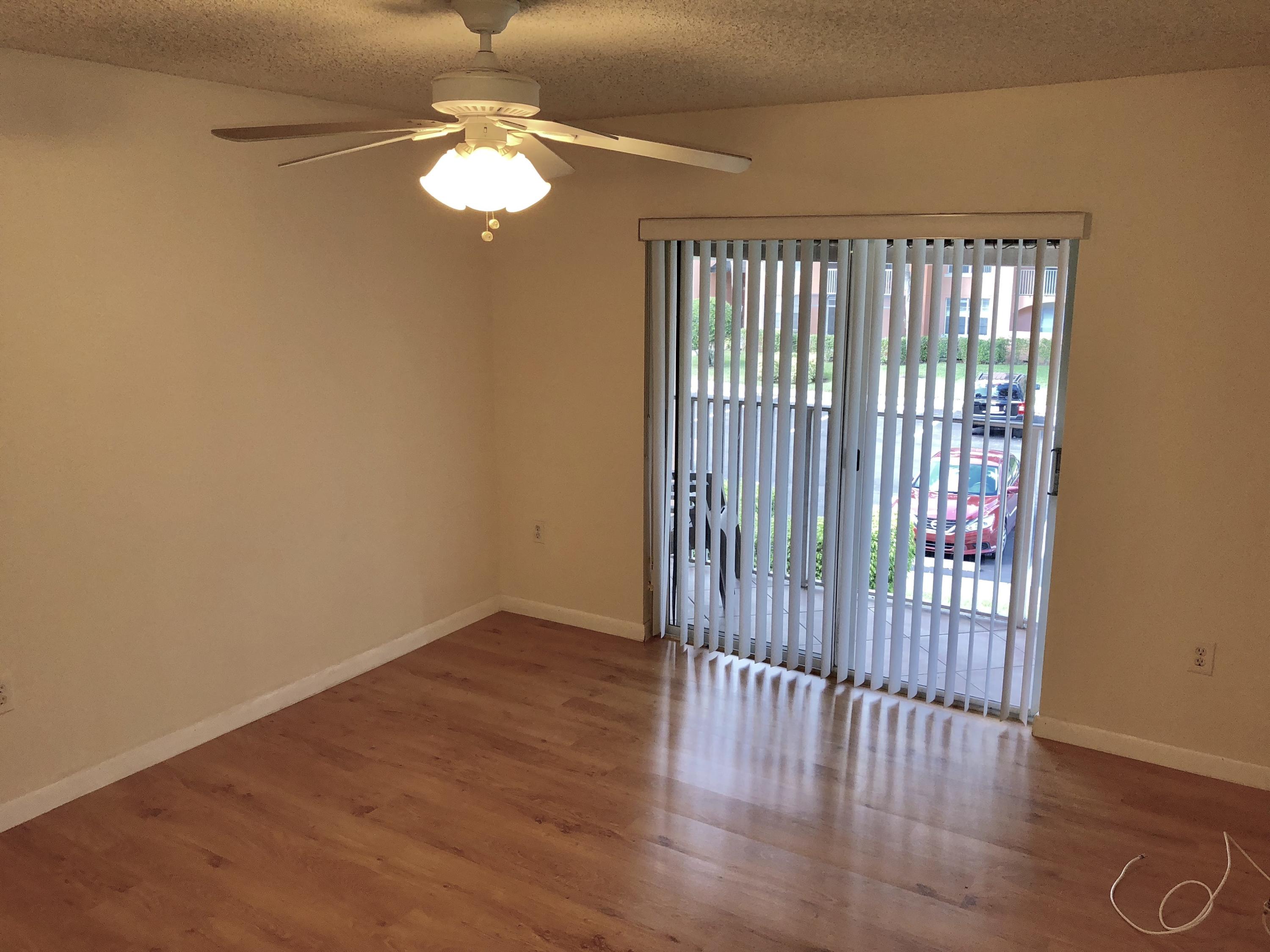 3133 Clint Moore Road, Unit 201 Boca Raton, FL 33496 - Photo 11 of 15 a view of an empty room with wooden floor and a window
