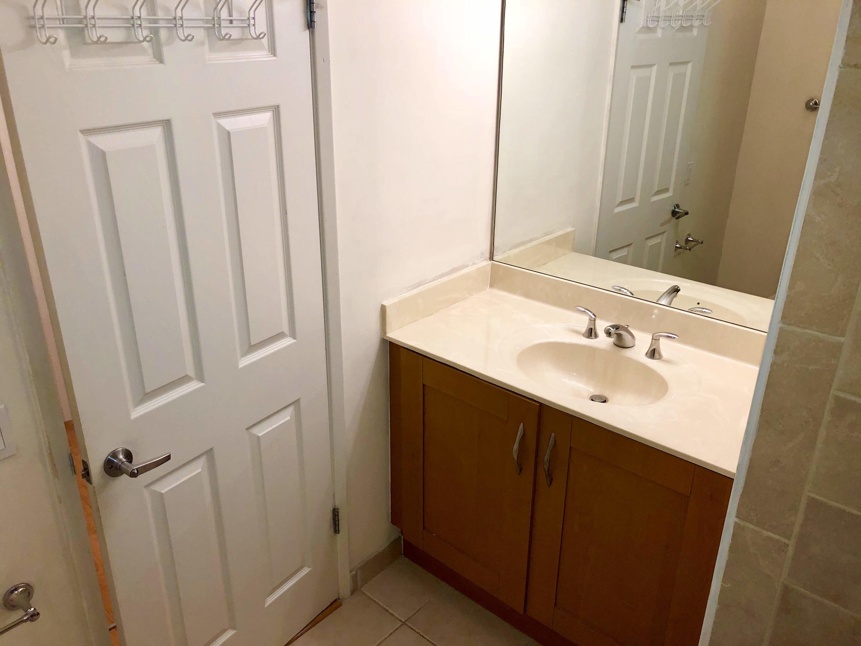 3133 Clint Moore Road, Unit 201 Boca Raton, FL 33496 - Photo 15 of 15 a bathroom with a sink a mirror and a shower