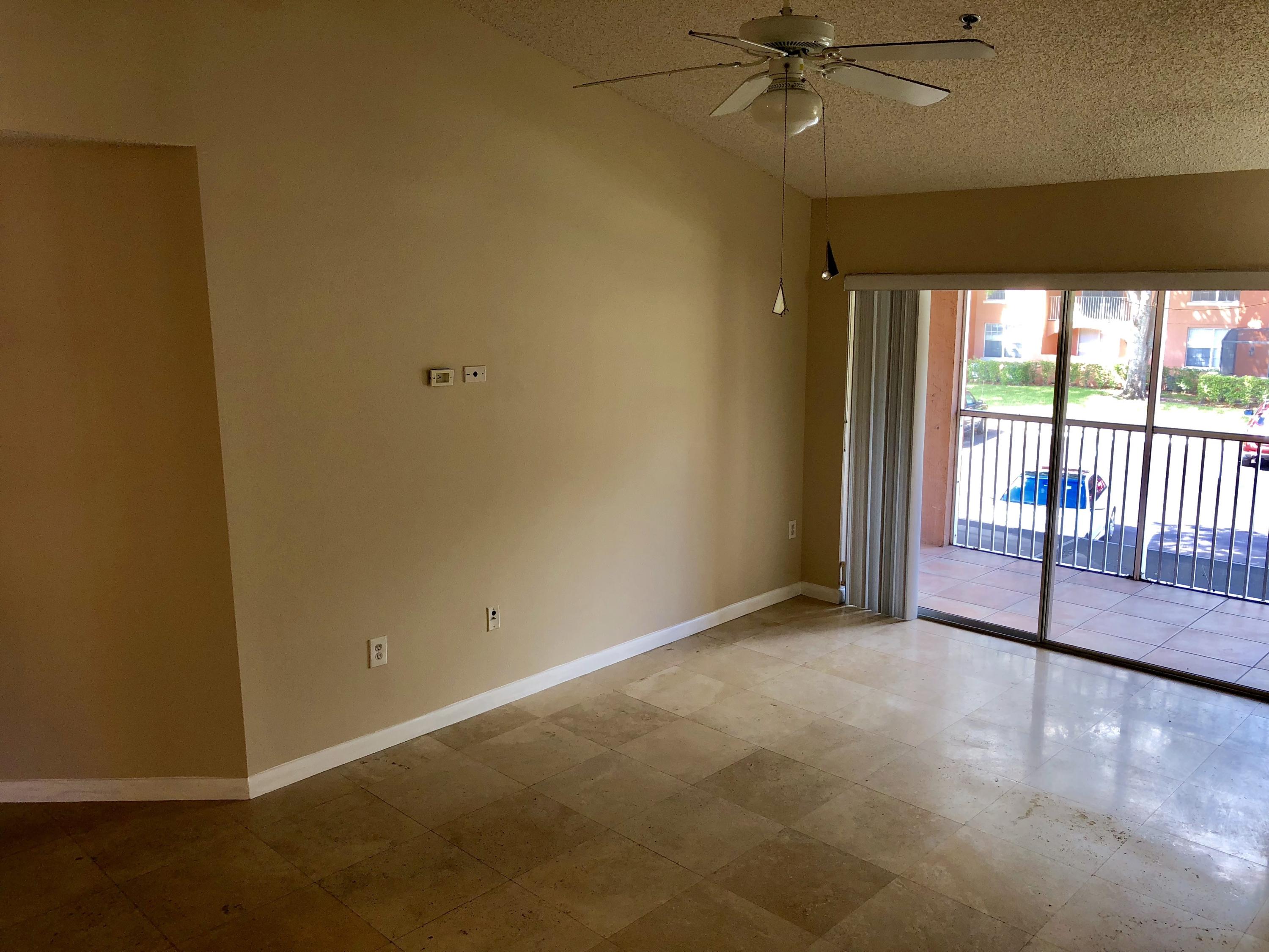 3133 Clint Moore Road, Unit 201 Boca Raton, FL 33496 - Photo 3 of 15 an empty room with a ceiling fan and a window
