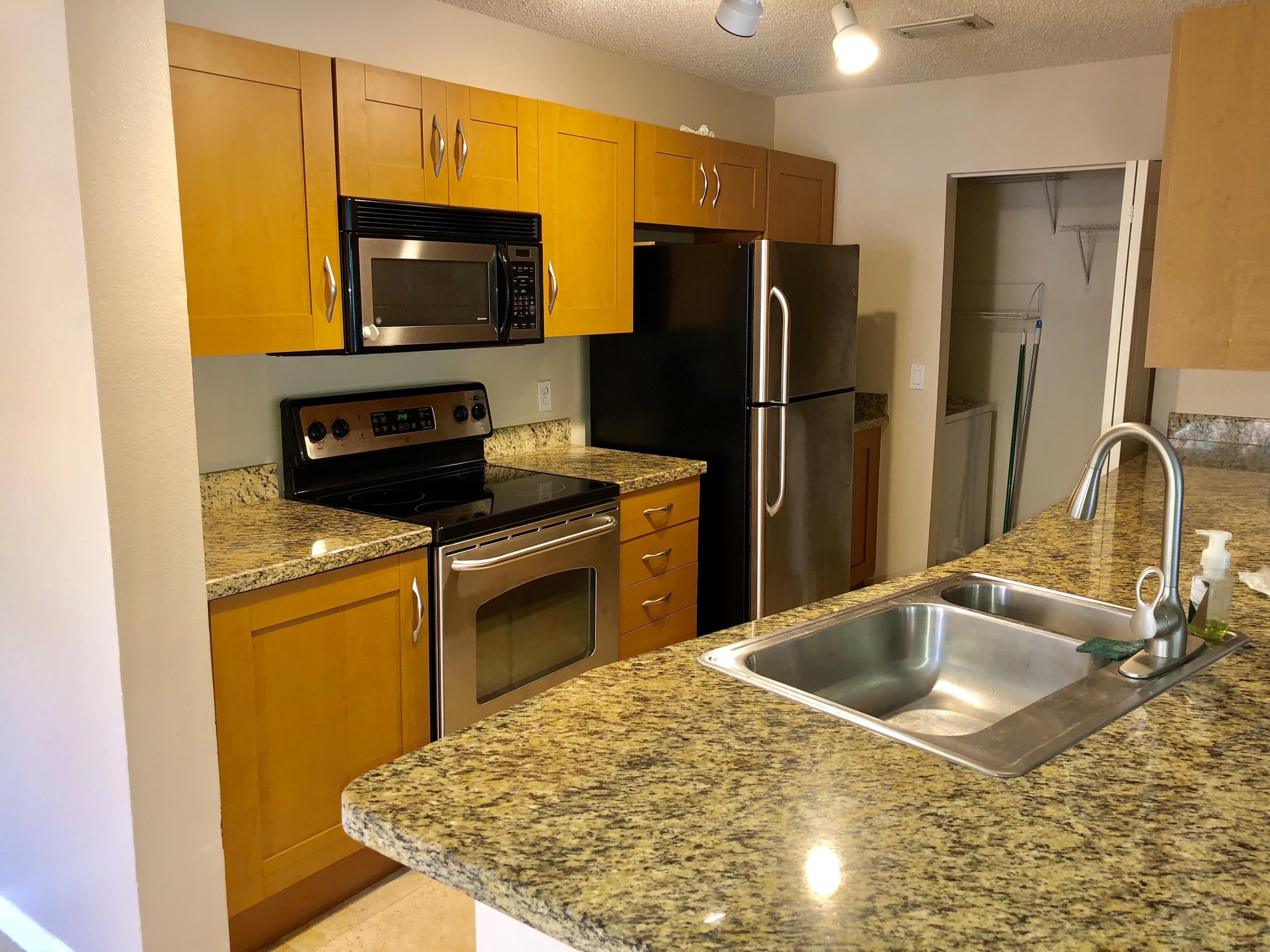 3133 Clint Moore Road, Unit 201 Boca Raton, FL 33496 - Photo 7 of 15 a kitchen with a sink stove and refrigerator