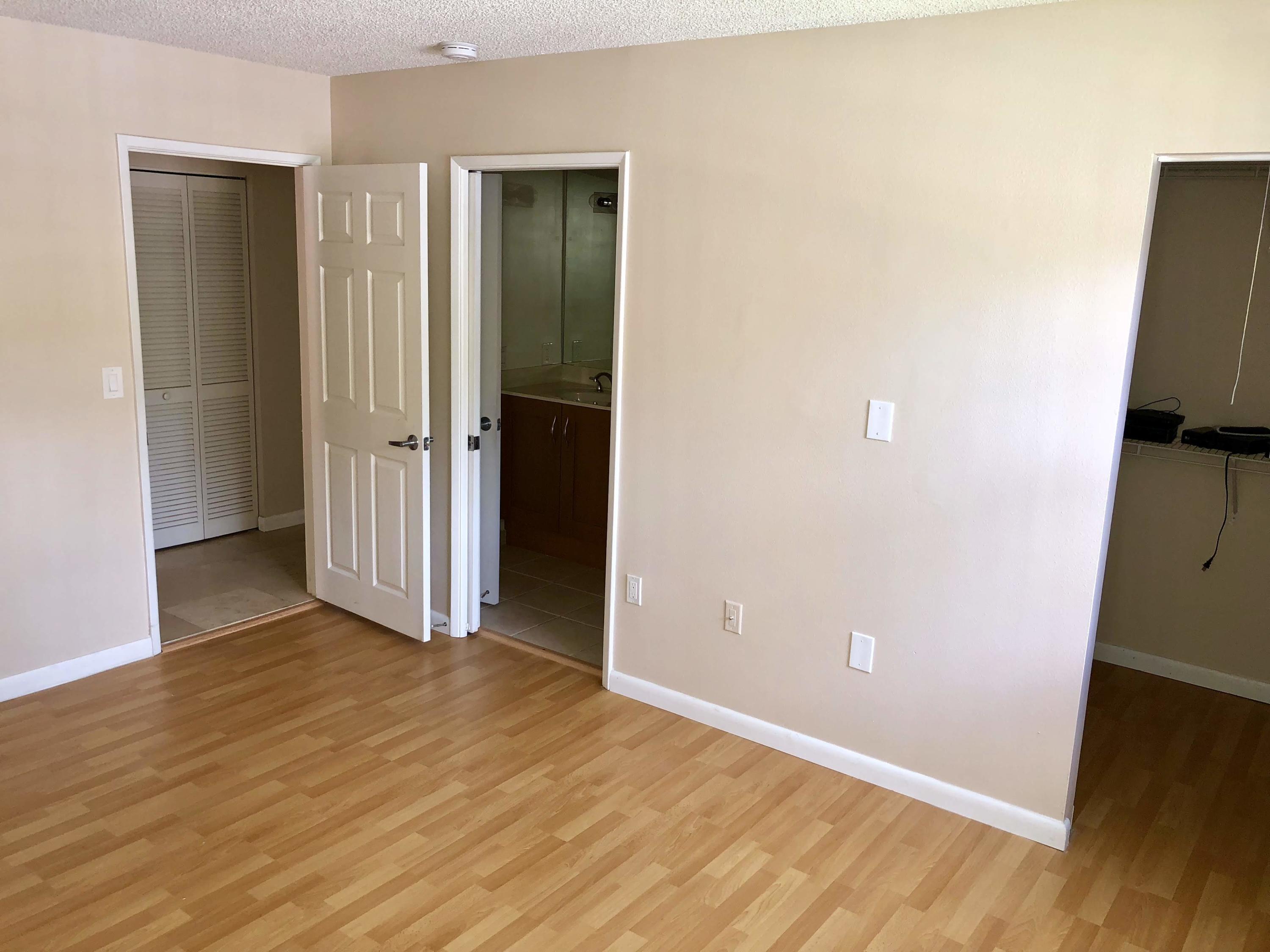 3133 Clint Moore Road, Unit 201 Boca Raton, FL 33496 - Photo 9 of 15 an empty room with wooden floor and closet