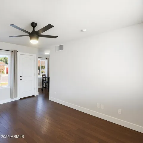 a view of an empty room with wooden floor