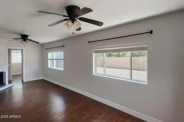 a room with window a ceiling fan and wooden floor