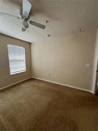 an empty room with windows and ceiling fan