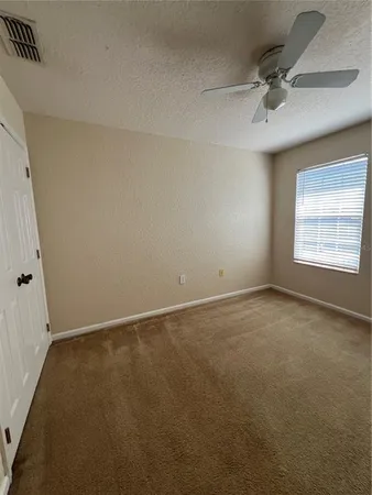 a view of empty room with ceiling fan