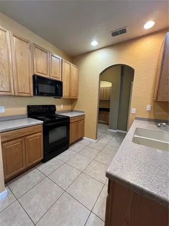 a view of a kitchen with white cabinets and a sink