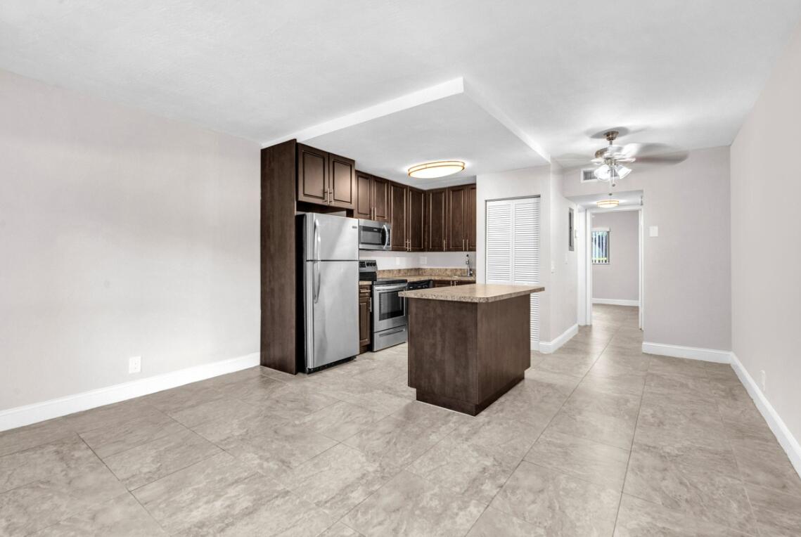 559 Northeast 44th Street, Unit 2 Boca Raton, FL 33431 - Photo 2 of 4 a kitchen with stainless steel appliances a refrigerator and a stove top oven