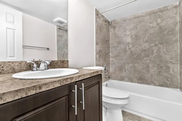 a bathroom with a granite countertop sink toilet and shower