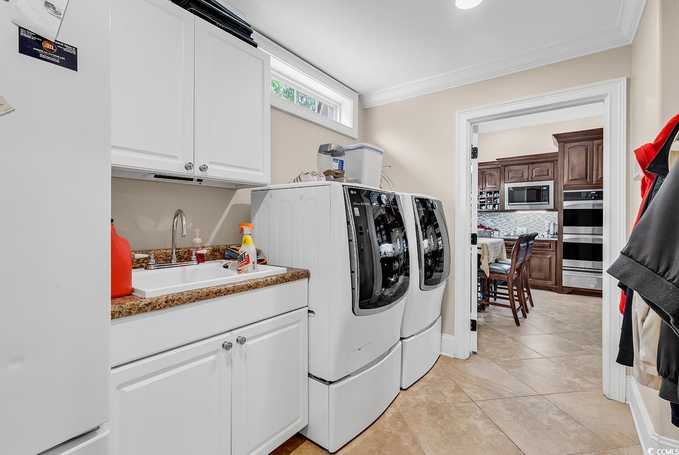 487 Trestle Way Conway, SC 29526 - Photo 11 of 40 Laundry area with independent washer and dryer, cabinet space, crown molding, and light tile patterned flooring