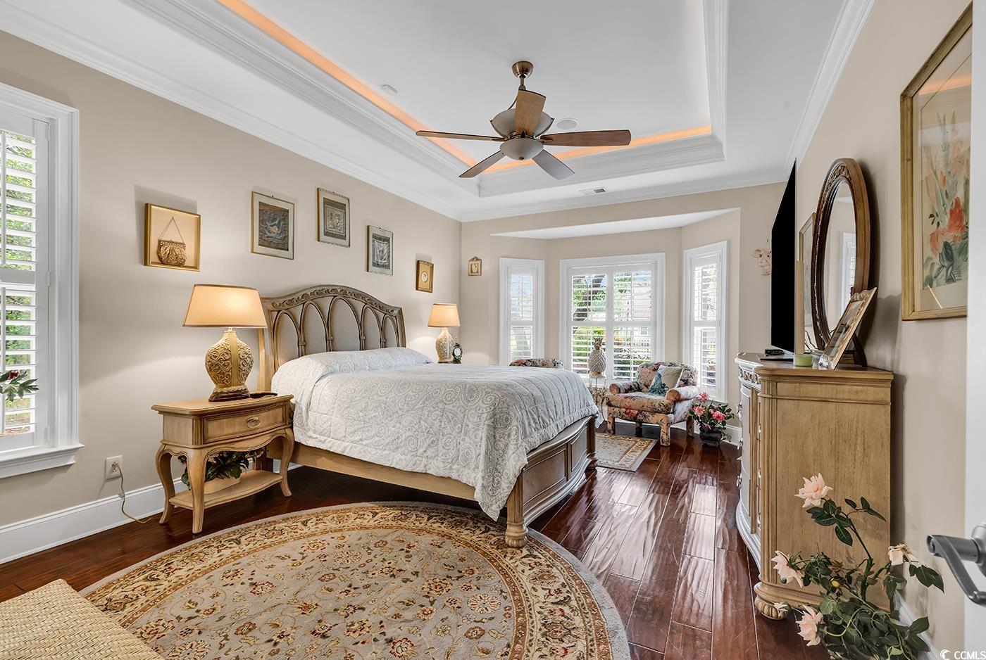 487 Trestle Way Conway, SC 29526 - Photo 18 of 40 Bedroom with a raised ceiling, dark wood-style floors, crown molding, and a ceiling fan