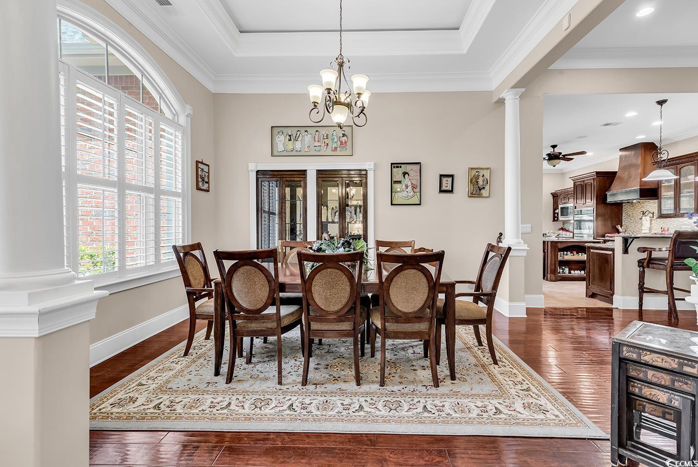487 Trestle Way Conway, SC 29526 - Photo 4 of 40 Dining room with ornate columns, dark wood finished floors, ornamental molding, a chandelier, and a tray ceiling