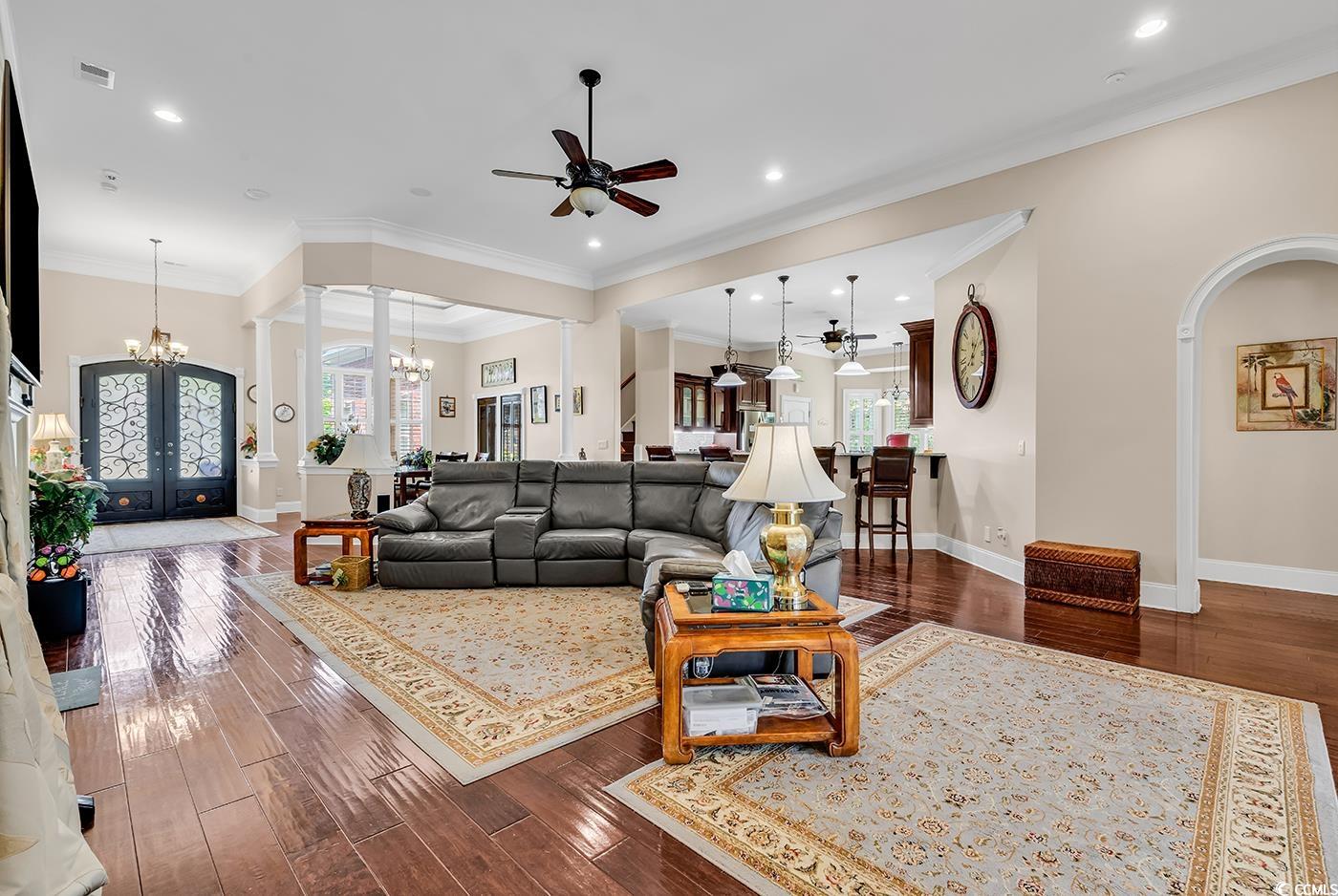 487 Trestle Way Conway, SC 29526 - Photo 7 of 40 Living room with a chandelier, ceiling fan, plenty of natural light, dark wood-style floors, and crown molding