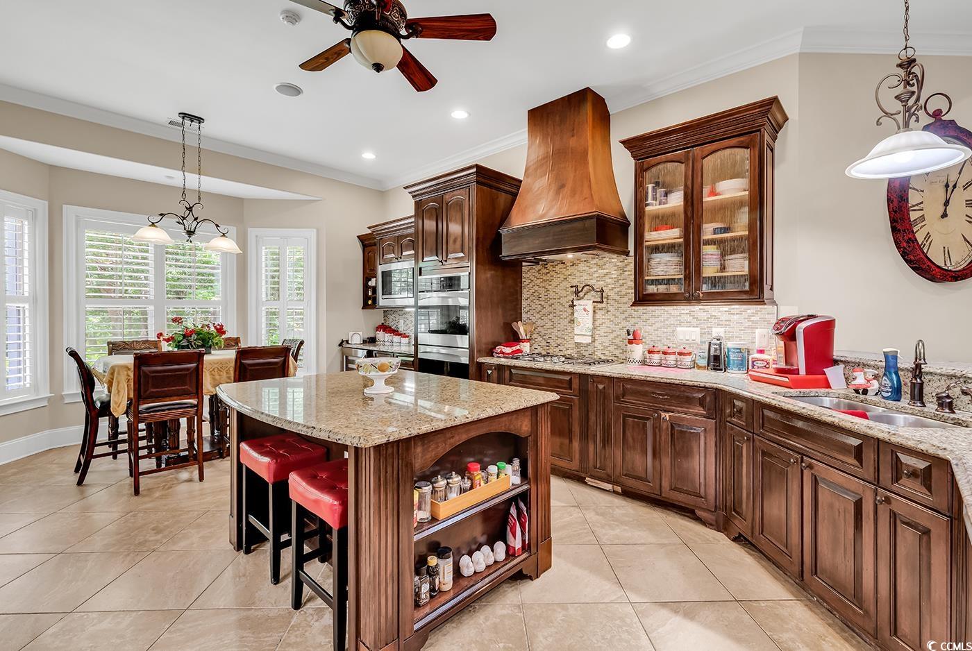 487 Trestle Way Conway, SC 29526 - Photo 9 of 40 Kitchen featuring stainless steel appliances, custom range hood, ceiling fan, ornamental molding, and light stone countertops