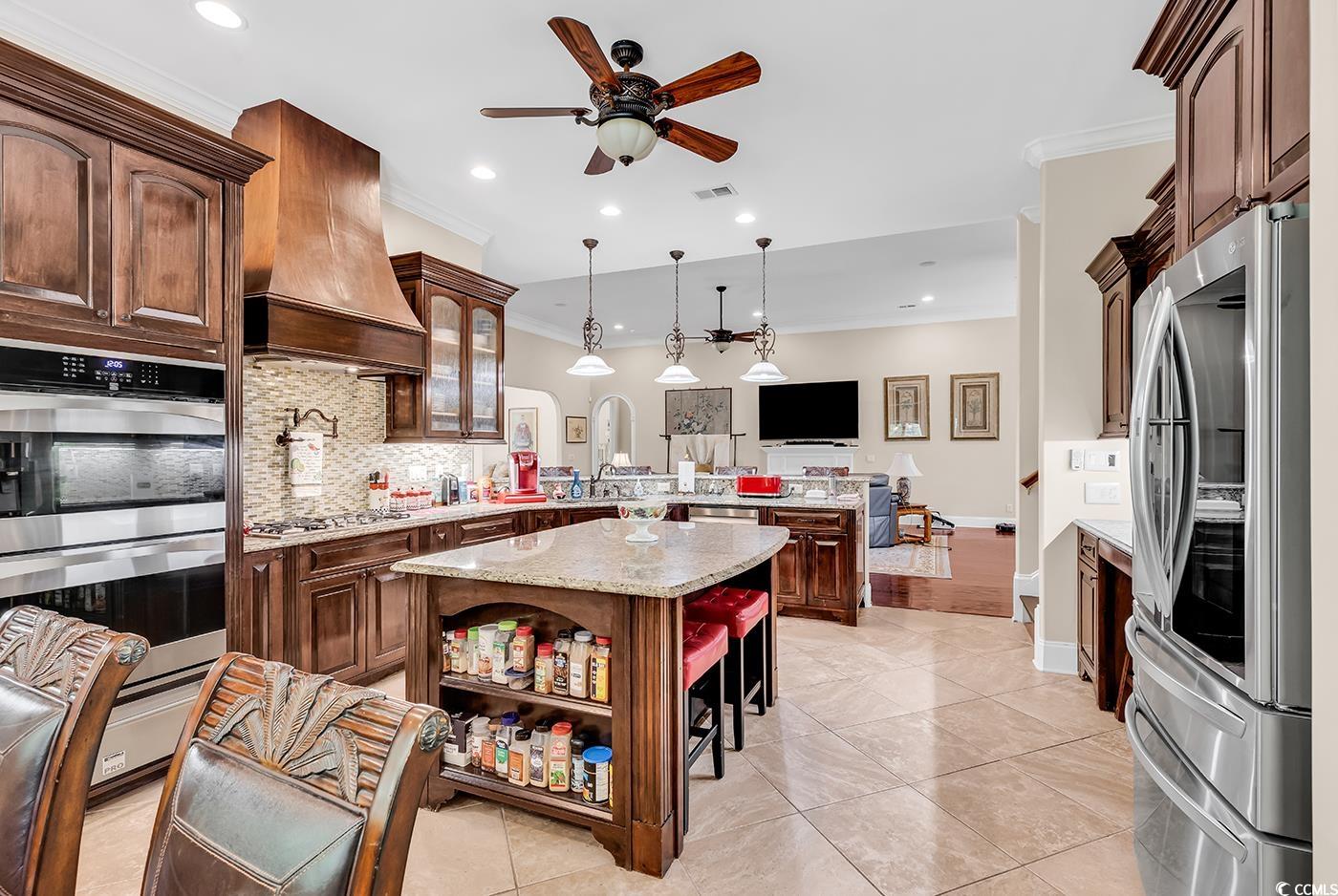 487 Trestle Way Conway, SC 29526 - Photo 10 of 40 Kitchen with appliances with stainless steel finishes, a peninsula, crown molding, custom range hood, and tasteful backsplash