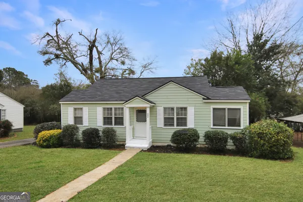 a front view of a house with a garden