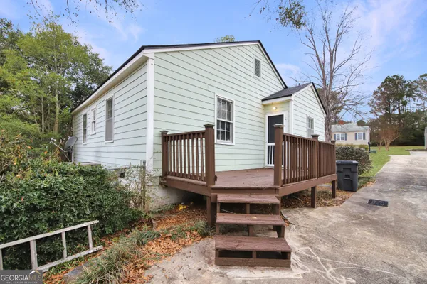 a view of a house with a wooden deck and a yard