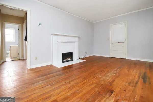 a view of empty room with wooden floor and fireplace