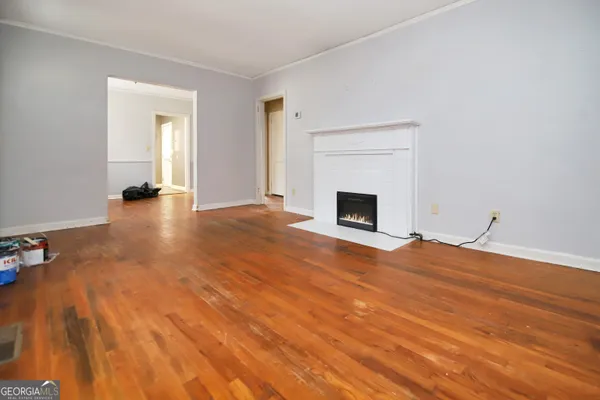 a view of empty room with wooden floor and fireplace