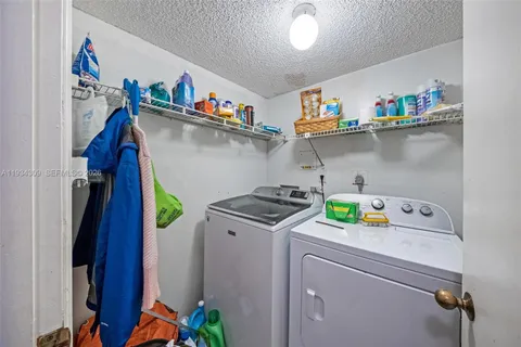 a utility room with lots of clutter and cabinets